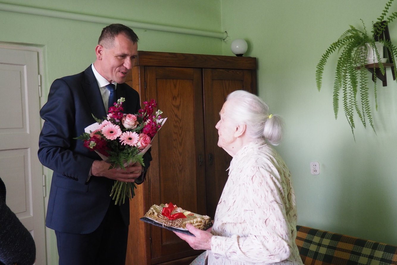 Pani Wiktoria Bożek przyjmuje  kwiaty i życzenia z rąk Kierownika Placówki Terenowej KRUS w Ropczycach Marka Pająka